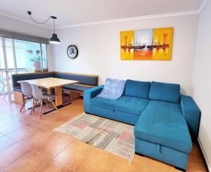 - un salon avec un canapé bleu et une table dans l'établissement Lua do Mar, à Caniço