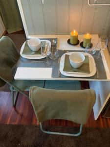 - une table avec deux assiettes et des bougies dans l'établissement Idyllisk lite anneks med enestående uteplass, à Larvik