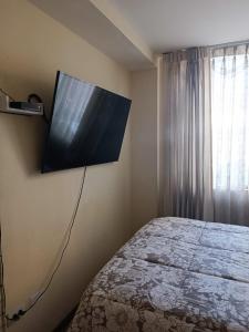 a bedroom with a bed and a flat screen tv on the wall at Departamento zona exclusiva Cayma Arequipa in Cayma
