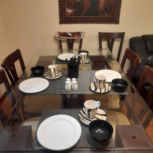 a dining room table with white plates and chairs at Departamento zona exclusiva Cayma Arequipa in Cayma