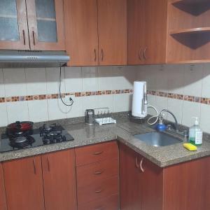 a kitchen with a sink and a stove and cabinets at Departamento zona exclusiva Cayma Arequipa in Cayma