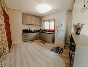 eine leere Küche mit einem Kühlschrank und einem Tisch in der Unterkunft Apto Aconchegante com Vista - A 5 minutos do portico 1 e 1km do centro in Gramado