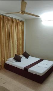 Cama en habitación con ventilador de techo en MercuryFM 103 Guest House - Colombo 3, en Colombo