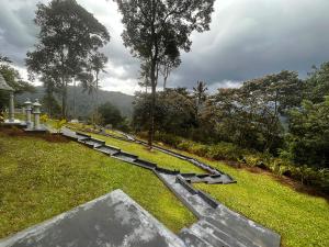a row of benches in a park with a mountain at Viceroy Luxury Mountain Resort and Spa in Munnar