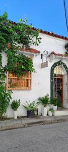 a white building with a window and plants at Hostal Casa Lara in Cartagena de Indias
