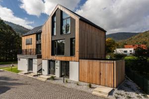 a house with wooden panels on the side of it at Klimczok Apartamenty in Bystra