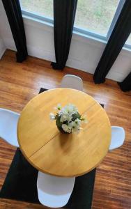 una mesa de madera con un jarrón de flores. en This Old House, en Detroit