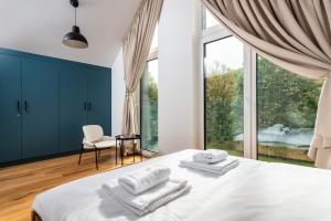 1 dormitorio con cama blanca y ventana grande en Klimczok Apartamenty en Bystra