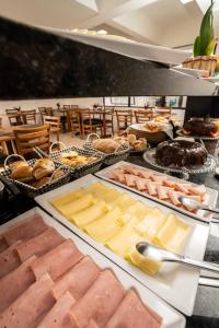 a buffet line with meats and cheese and pastries at Boulevard Central Canasvieiras Hotel in Florianópolis