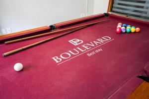 a red pool table with balls and bats on it at Boulevard Central Canasvieiras Hotel in Florianópolis