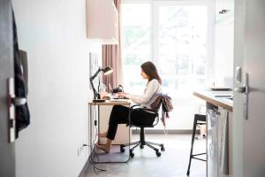 a woman sitting at a desk in an office at Résidence Kley Angers Centre in Angers