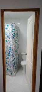 a bathroom with a toilet and a shower curtain at Loftdonalejandro in Machalí