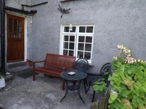a bench and a table in front of a building at 18th Century character cottage, Broughton-in-Furness in Broughton in Furness