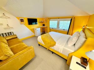a yellow bedroom with a bed and a couch at Peninsula Bed & Cocktails in St. Petersburg