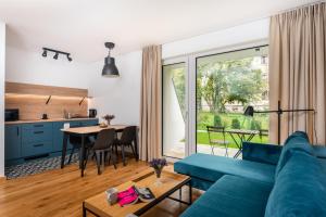 a living room with a blue couch and a table at Klimczok Apartamenty in Bystra