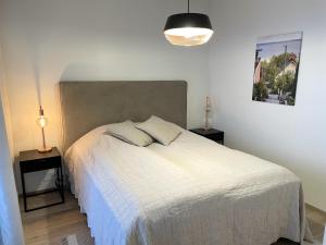 - une chambre avec un lit blanc et 2 tables de chevet dans l'établissement Bright two-room apartment near the centre, à Tampere