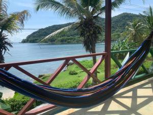 a hammock on a balcony with a view of the ocean at Hostal El Chileno Sapzurro in Sapzurro