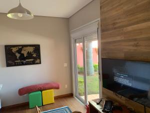a living room with a large flat screen tv at Casa na represa in Vargem