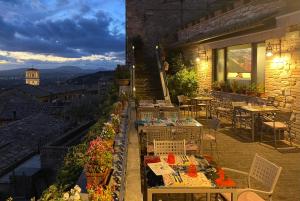 a restaurant with tables and chairs on a balcony at Hotel Berti in Assisi