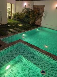 a swimming pool with turquoise tiles on the floor at Killamoon House Paracas in Paracas