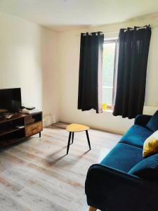 a living room with a blue couch and a table at T2 - au coeur de la roche in La Roche-sur-Yon