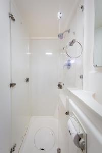 a white bathroom with a toilet and a shower at All Inclusive Luxury Yacht with Private Island in Cancún