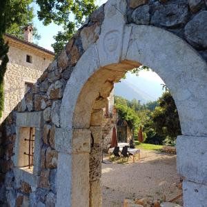 un arco en una pared de piedra con mesa y sillas en B&B Casal Cominium en San Donato Val di Comino