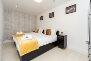 a bedroom with two beds with white and gold sheets at Modern One Bed Flat Lowestoft in Lowestoft