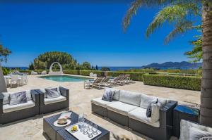 um pátio com 2 sofás e uma piscina em FRGK "Beautiful contemporary villa, with splendid panoramic sea view" em Cannes