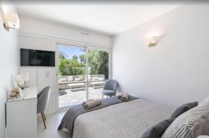 um quarto com uma cama, uma cadeira e uma janela em FRGK "Beautiful contemporary villa, with splendid panoramic sea view" em Cannes