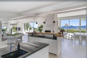 uma cozinha com electrodomésticos brancos e uma sala de jantar em FRGK "Beautiful contemporary villa, with splendid panoramic sea view" em Cannes