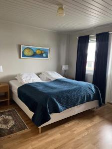 a bedroom with a bed with a blue blanket and a window at Henningsvær, Lofoten with fantastic view in Henningsvær