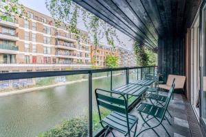 a balcony with chairs and a view of a river at Beautiful Canal-side Flat in Hackney in London