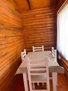 - une table et des chaises dans une chambre dotée de murs en bois dans l'établissement Rincón del Sur, à San Miguel del Monte