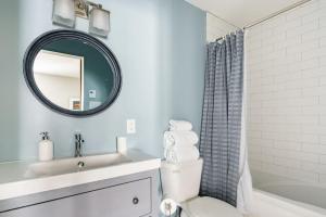 een badkamer met een wastafel, een toilet en een spiegel bij Luxury Condominium with Rustic Minimalist Style in Mont-Tremblant