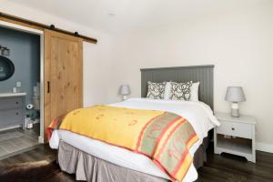 een slaapkamer met een groot bed en een gele deken bij Luxury Condominium with Rustic Minimalist Style in Mont-Tremblant