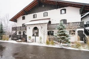 een groot wit huis met sneeuw op de grond bij Luxury Condominium with Rustic Minimalist Style in Mont-Tremblant