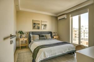 a bedroom with a bed and a large window at Modern 3BD Spacious Apartment with Terrace - Close to Yacht Marina in Msida