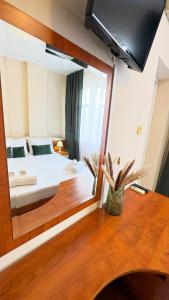a bedroom with a bed and a large mirror at Dezudava Family Hotel in Sandanski