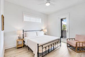 a white bedroom with a bed and a chair at Palmilla Beach Resort: Luxury Gulf Getaway in Port Aransas