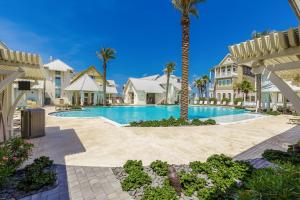 una piscina in un resort con palme e case di Palmilla Beach Resort: Luxury Gulf Getaway a Port Aransas