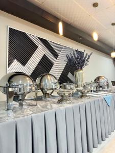 a table with silver dishes on top of it at Hotel La Quinta in La Ceiba