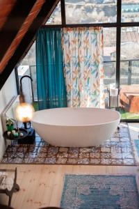 a large white bath tub in a room with a window at Cottage Veranda in Kazbegi
