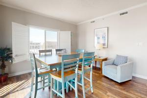 a dining room with a table and chairs and a couch at Whispering Sands 301 in Ocean City
