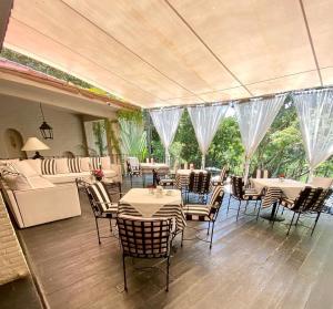 a dining room with tables and chairs and windows at Il Piccolo Peccato in Cuernavaca