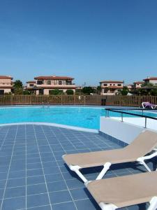 a swimming pool with two lounge chairs next to it at Marine Melody House - Perfect for relaxing getaway in Lajares