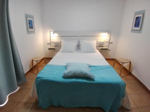 a bedroom with a bed with a blue blanket at Marine Melody House - Perfect for relaxing getaway in Lajares +15 photos