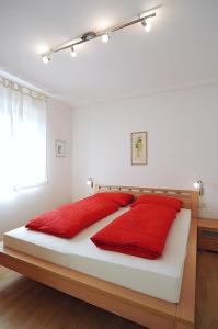 Un dormitorio con una cama con almohadas rojas. en Georgshof, en Appiano sulla Strada del Vino