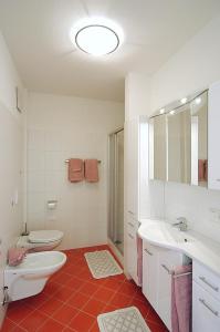 Baño blanco con aseo y lavamanos en Georgshof, en Appiano sulla Strada del Vino