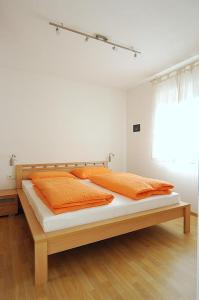 1 dormitorio con 1 cama con almohadas de color naranja en Georgshof, en Appiano sulla Strada del Vino